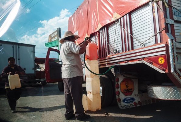 Un hombre llena el tanque de un camión con gasolina robada Credit Rodrigo Cruz para The New York Times